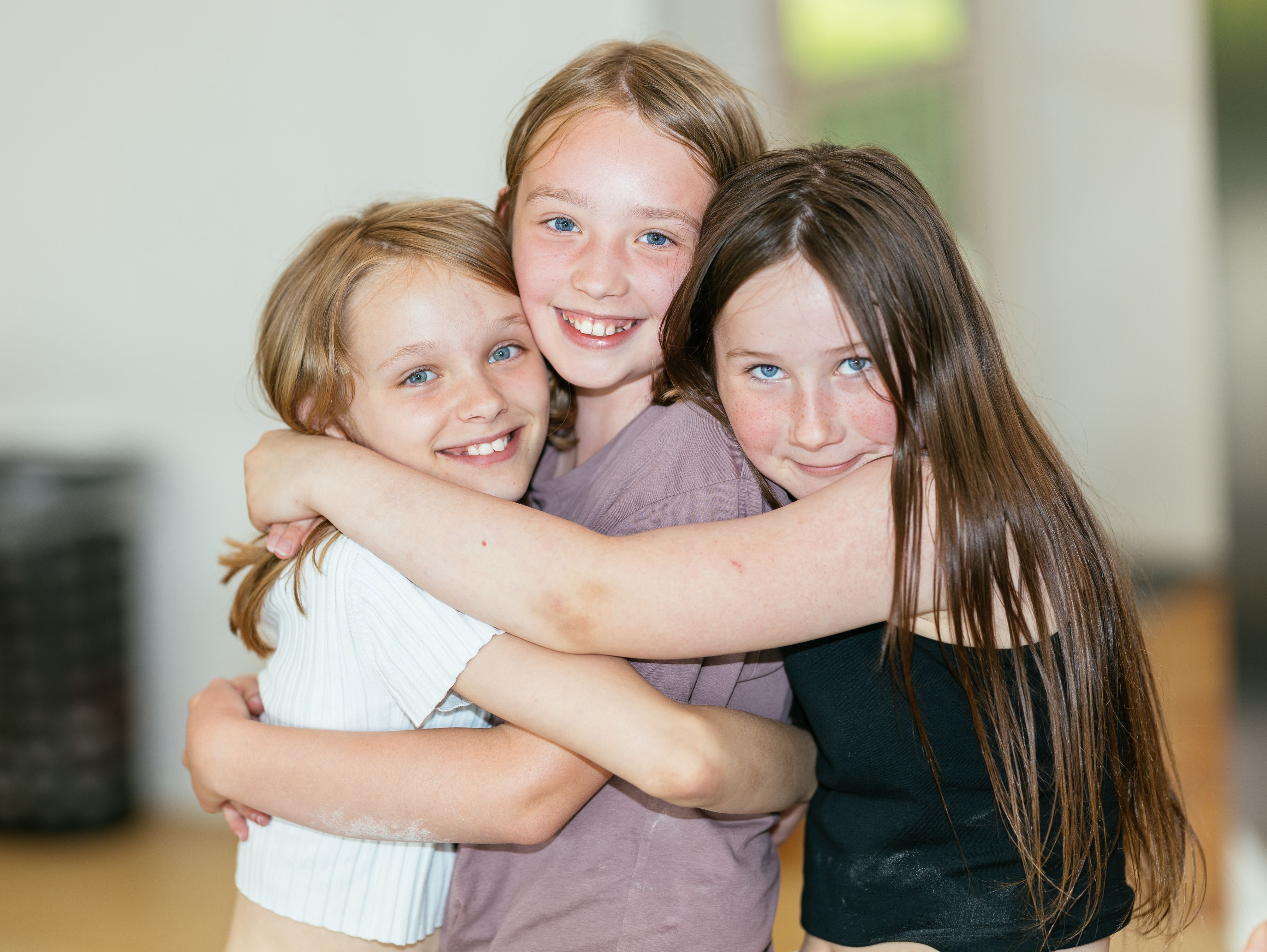 Tre piger krammer hinanden